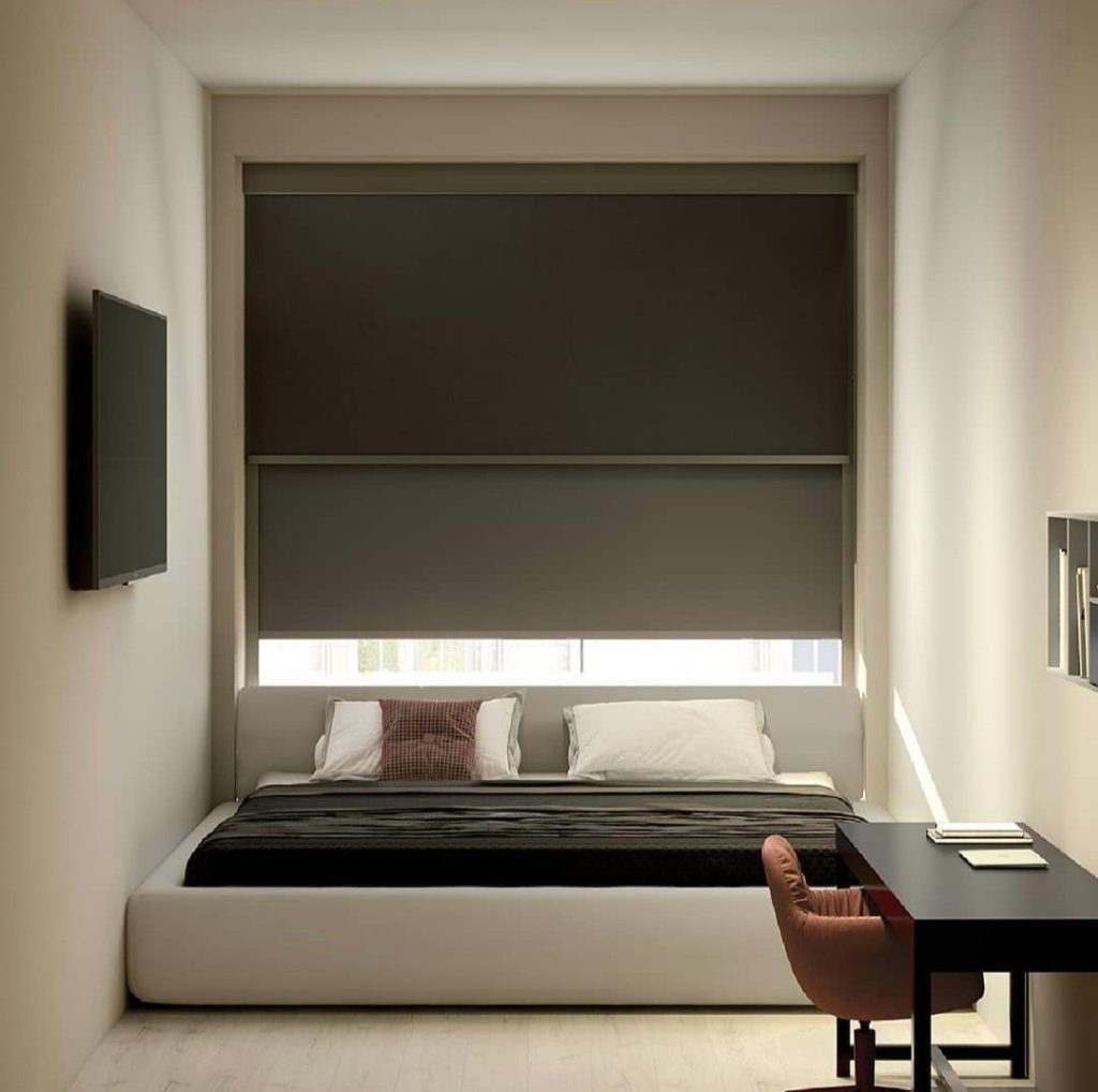 Habitación minimalista con persiana enrollable marrón oscuro que proporciona privacidad y control de luz.